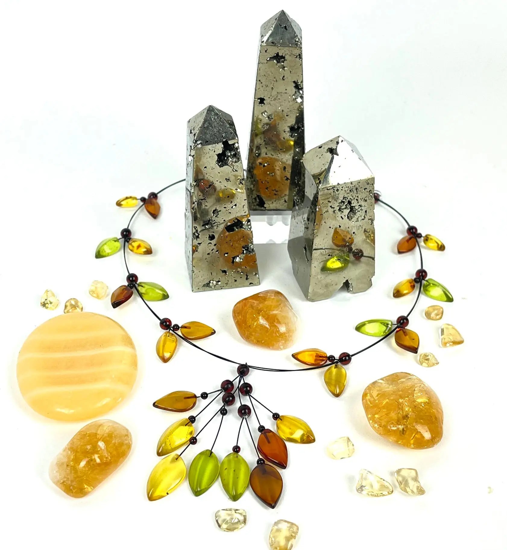 Close-up of various yellow and gold crystals, including citrine, topaz, and possibly others, arranged on a textured surface.