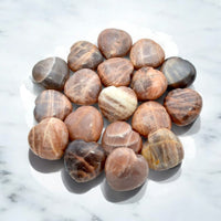 Pile of polished peach Moonstones heart-shaped gemstones for jewelry crafting