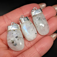 Thumbnail for Close-up of a person holding crystal pendants, featuring Rainbow Moonstone AAA Tumbled Pendant