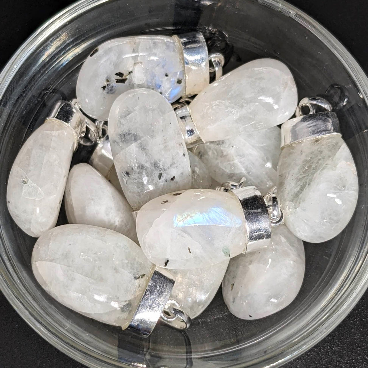 A bowl filled with white crystals for 1 Rainbow Moonstone AAA Tumbled Pendant SK6874