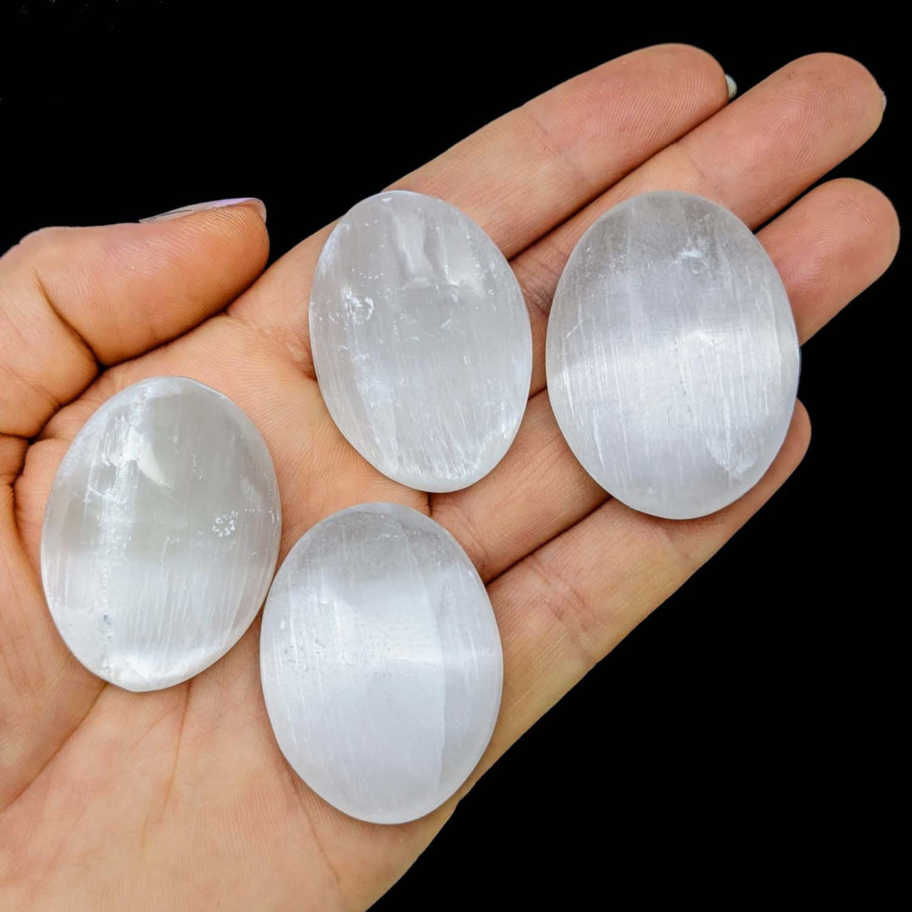 Four luminous selenite mini palm stones perfect for referral history and reward notifications