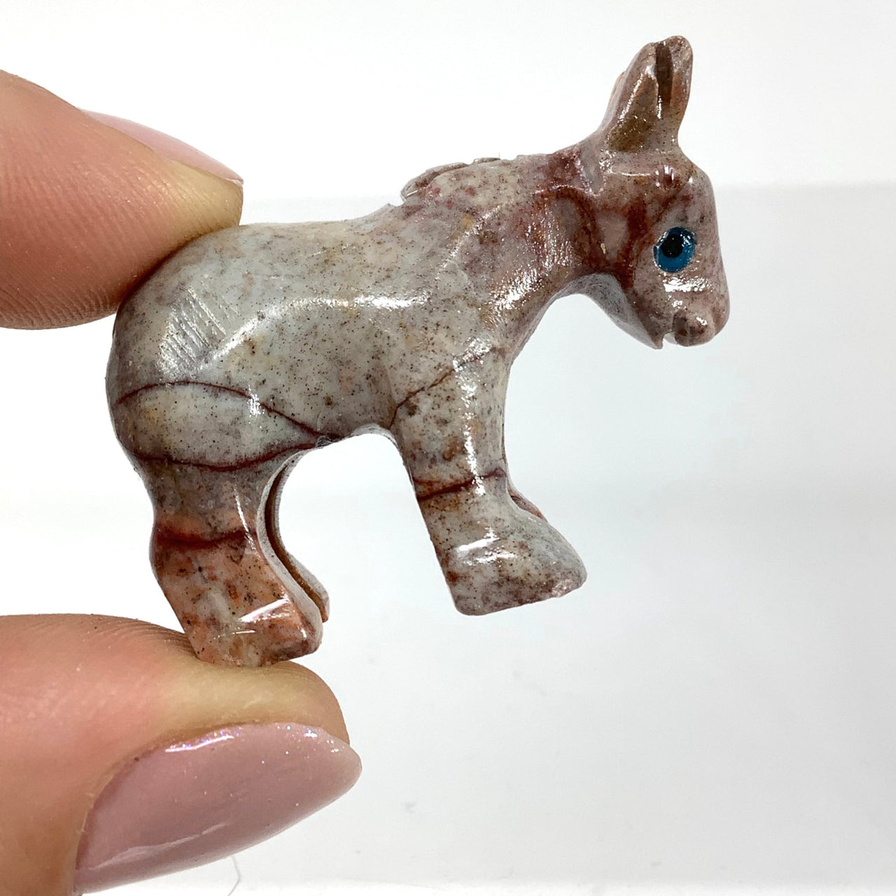 Soapstone baby animal carving from Peru with blue eye detail on its back