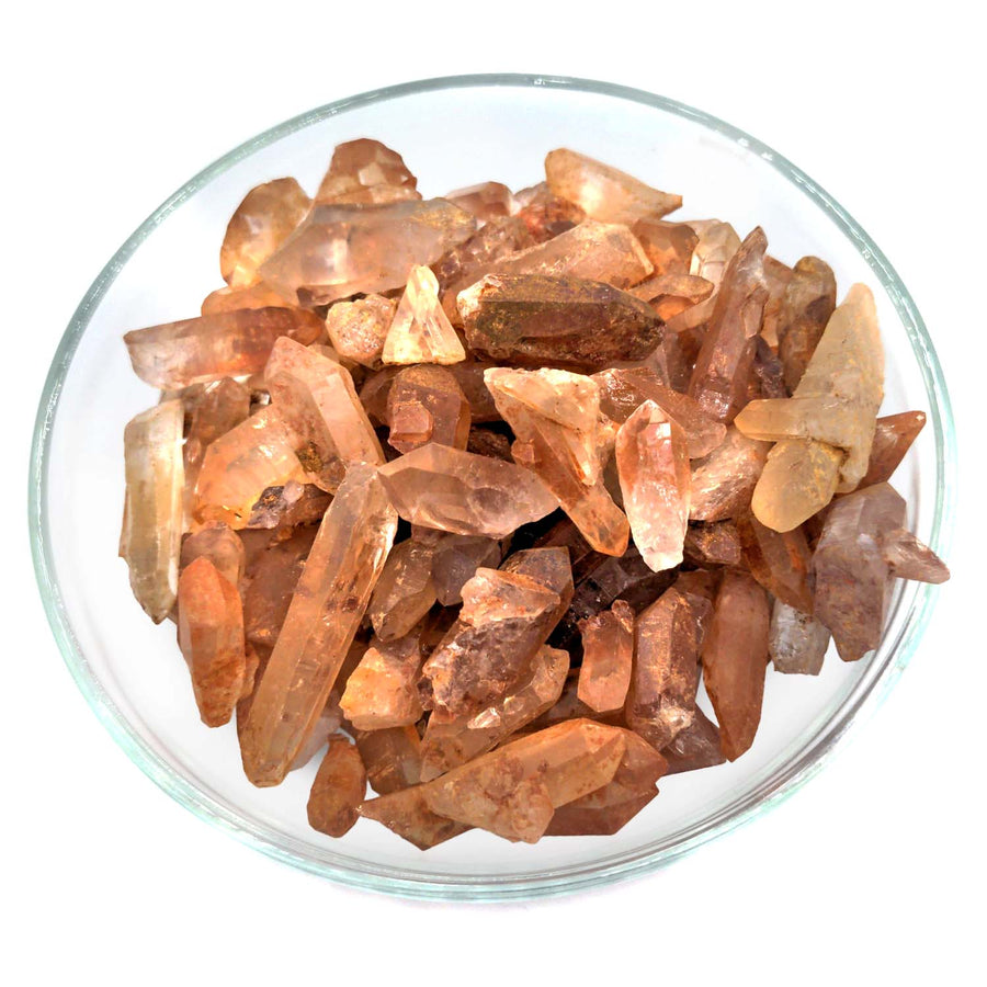 Raw pink and peach Tangerine Quartz Rough Points in a glass bowl