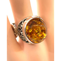 Thumbnail for A close-up of a Baltic amber ring with a yellow stone on a finger