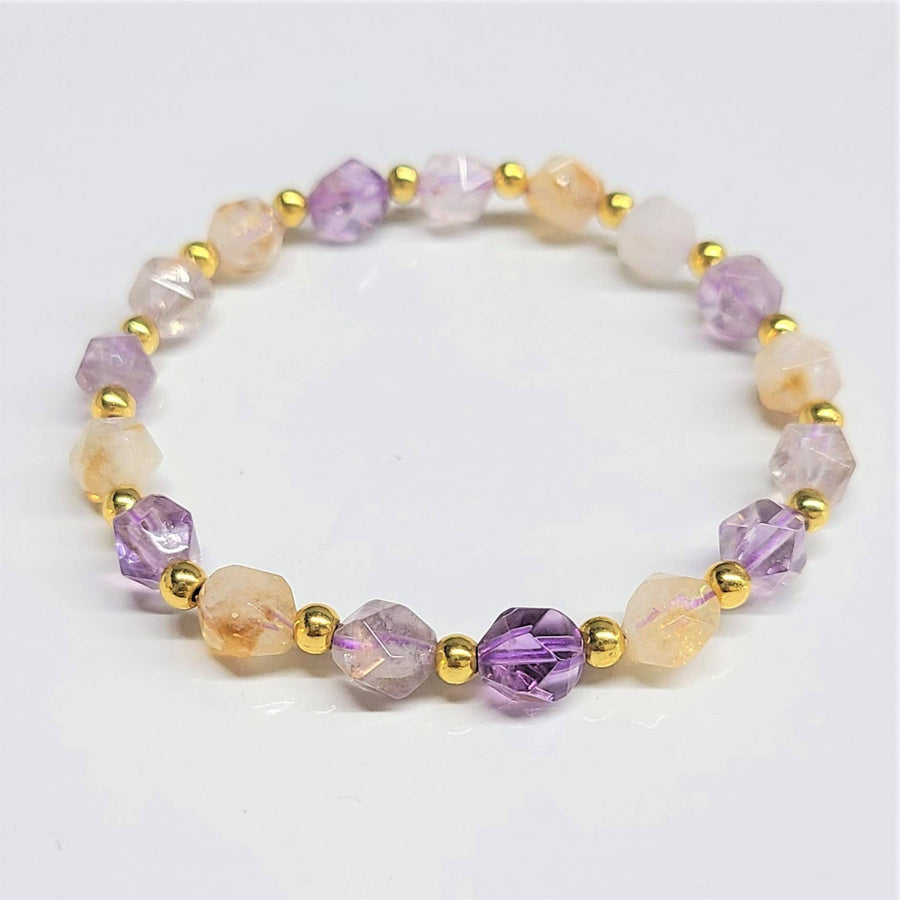 A delicate 8 mm faceted citrine and amethyst bracelet with alternating purple and peach gemstones and gold-toned beads