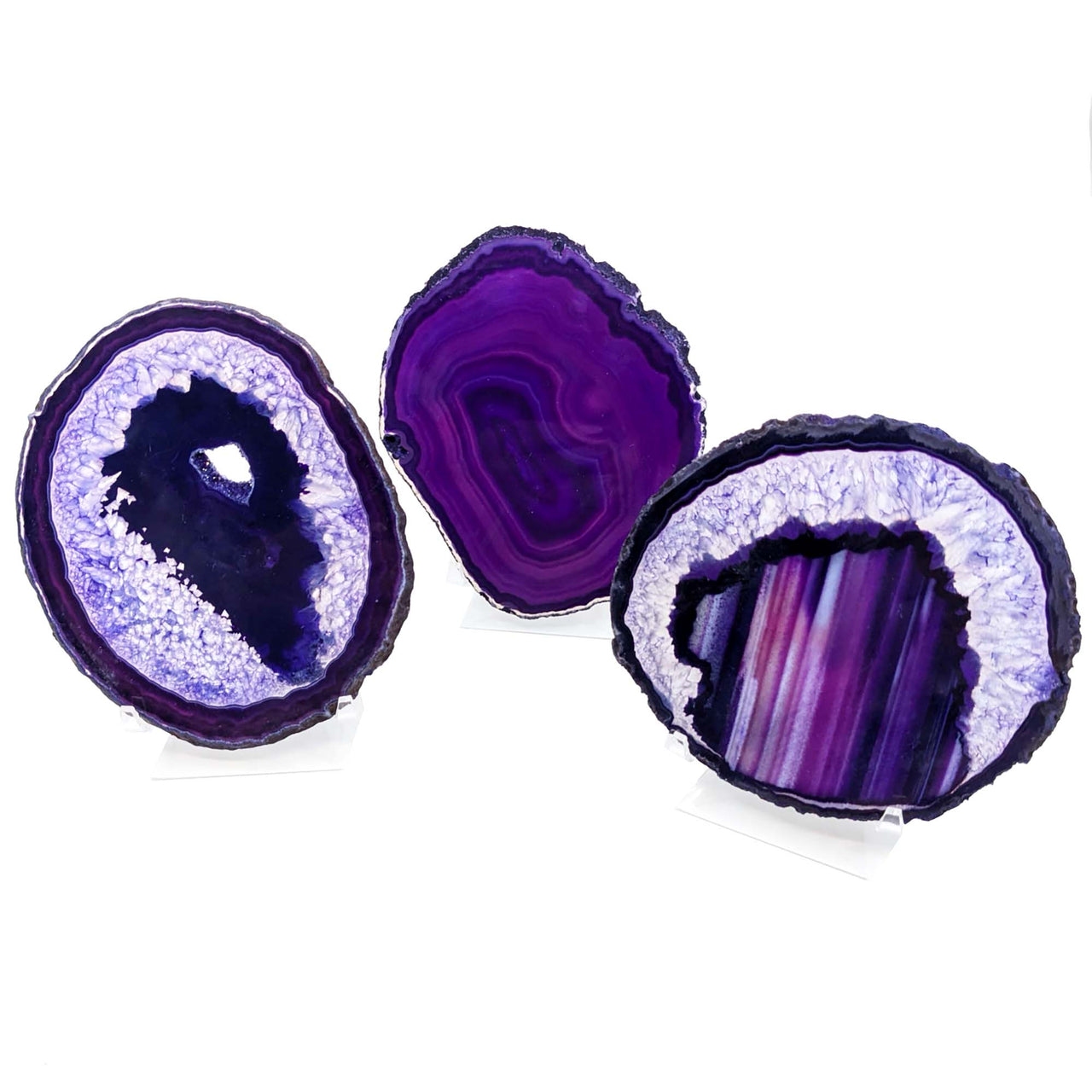 Three sliced purple agate geodes featuring stunning crystalline banding patterns