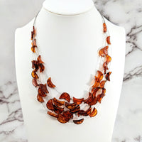 Thumbnail for Amber Crescent Moon Floating Wire Necklace accented with orange leaves on a white mannequin