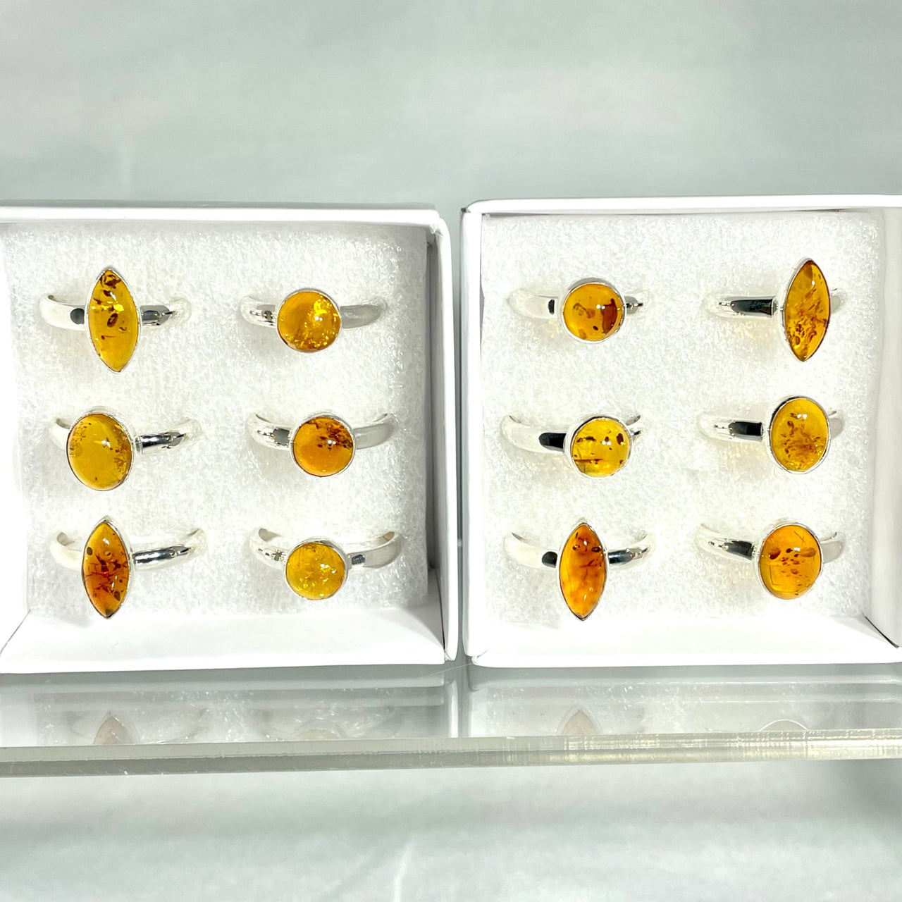 Amber Sterling Silver Ring J825 on display in white trays with silver-colored bands