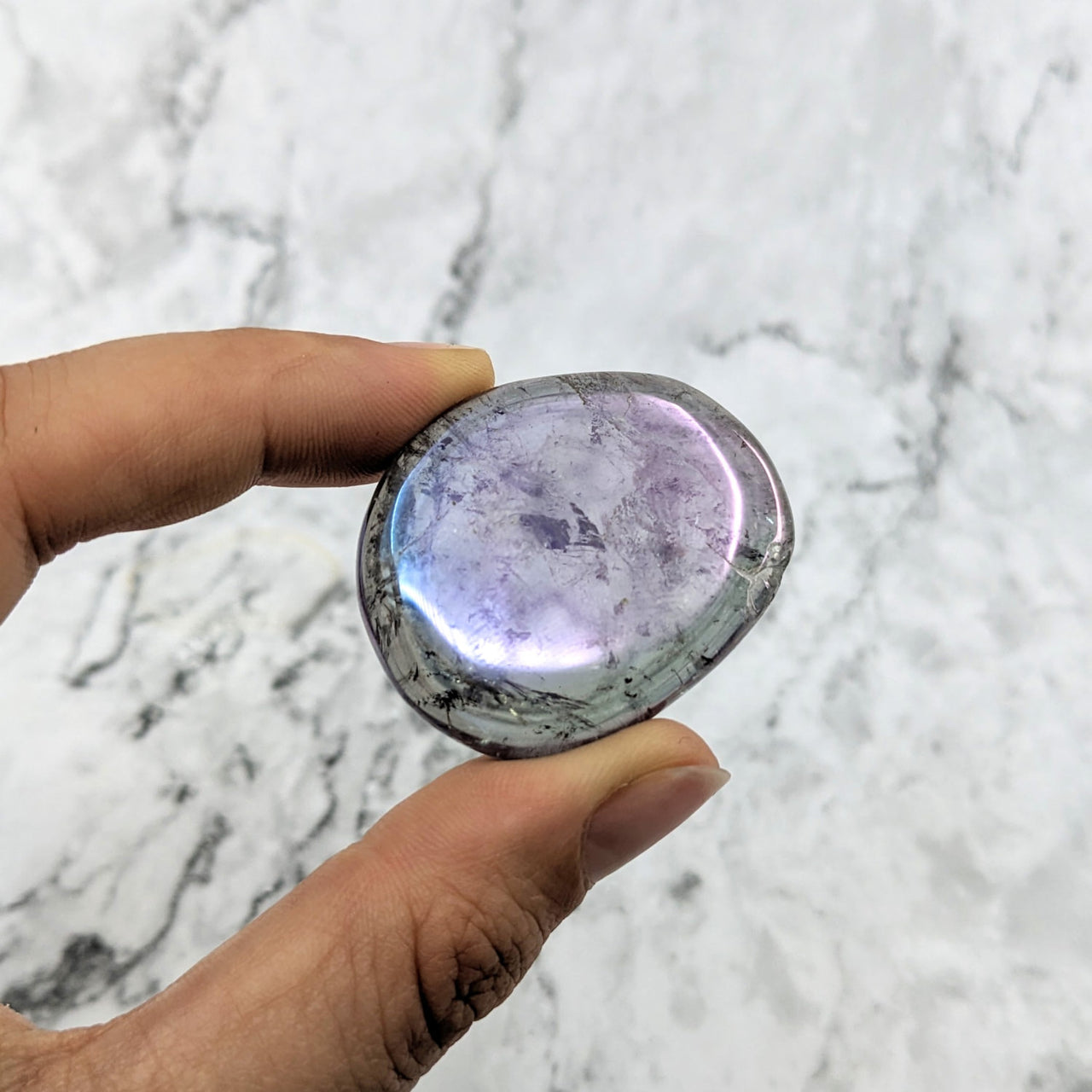 Hand holding a large purple Amethyst Rainbow Aura Quartz palm stone #LV2018