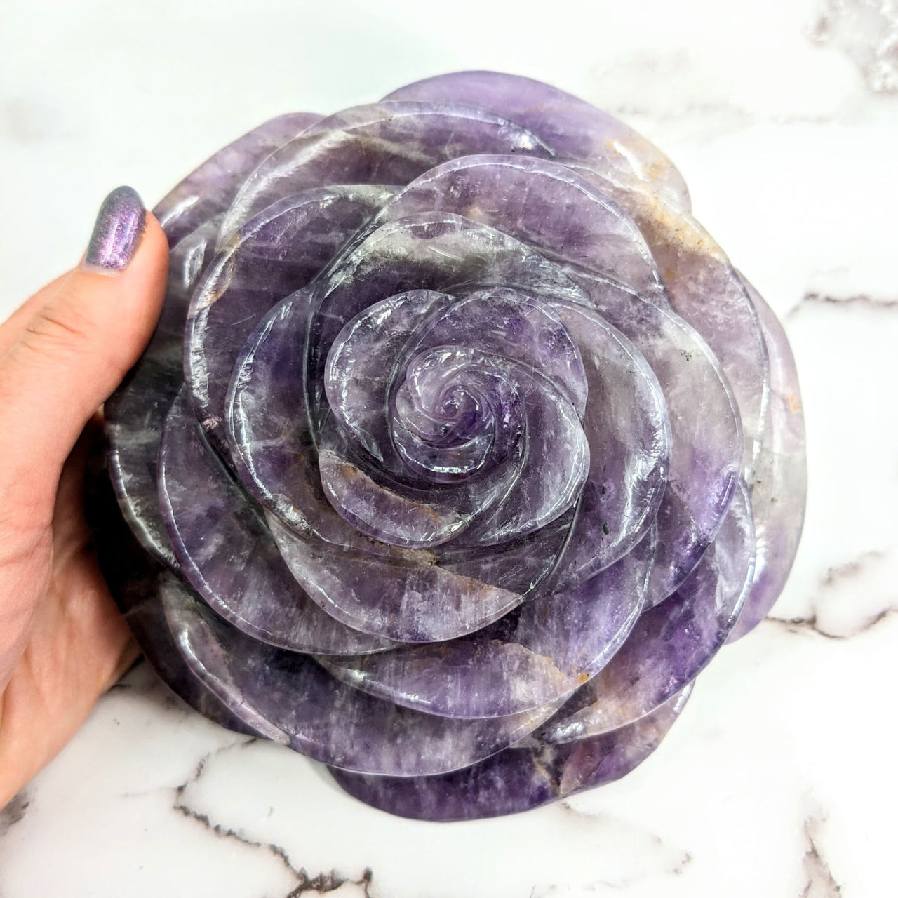 Person holding Amethyst Jumbo Rose Carving showcasing a purple rock in rose shape