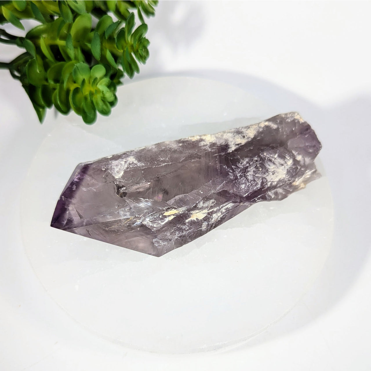 Translucent purple Amethyst 4.5’’ rough point with inclusions on white surface