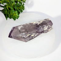 Translucent purple Amethyst 4.5’’ rough point with inclusions on white surface