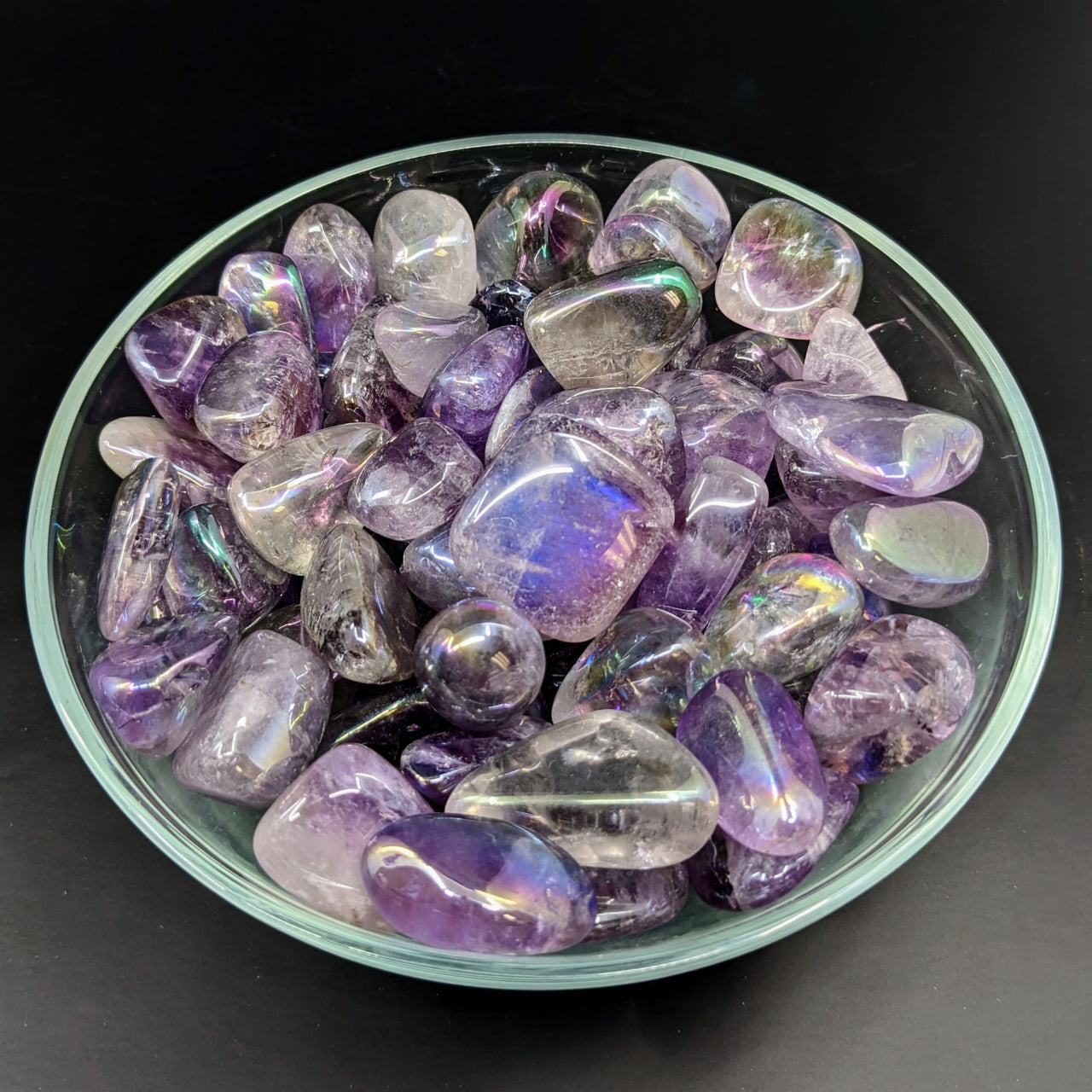 A bowl of Amethyst Aura .9-1.1’ Tumble Stones #LV2720, featuring premium tumbled stones