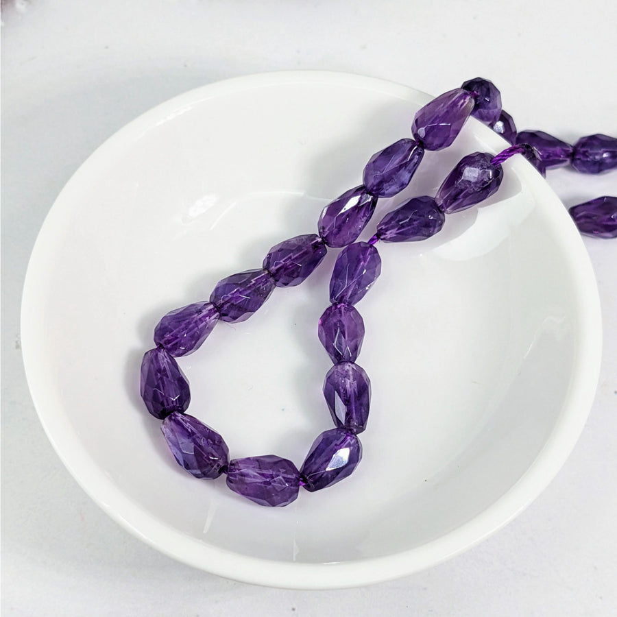 Amethyst Faceted 6 mm Teardrop Bead 6 Pack #LV3619 displayed on a white plate