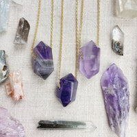 Three amethyst crystal necklaces with gold chains and faceted pendants