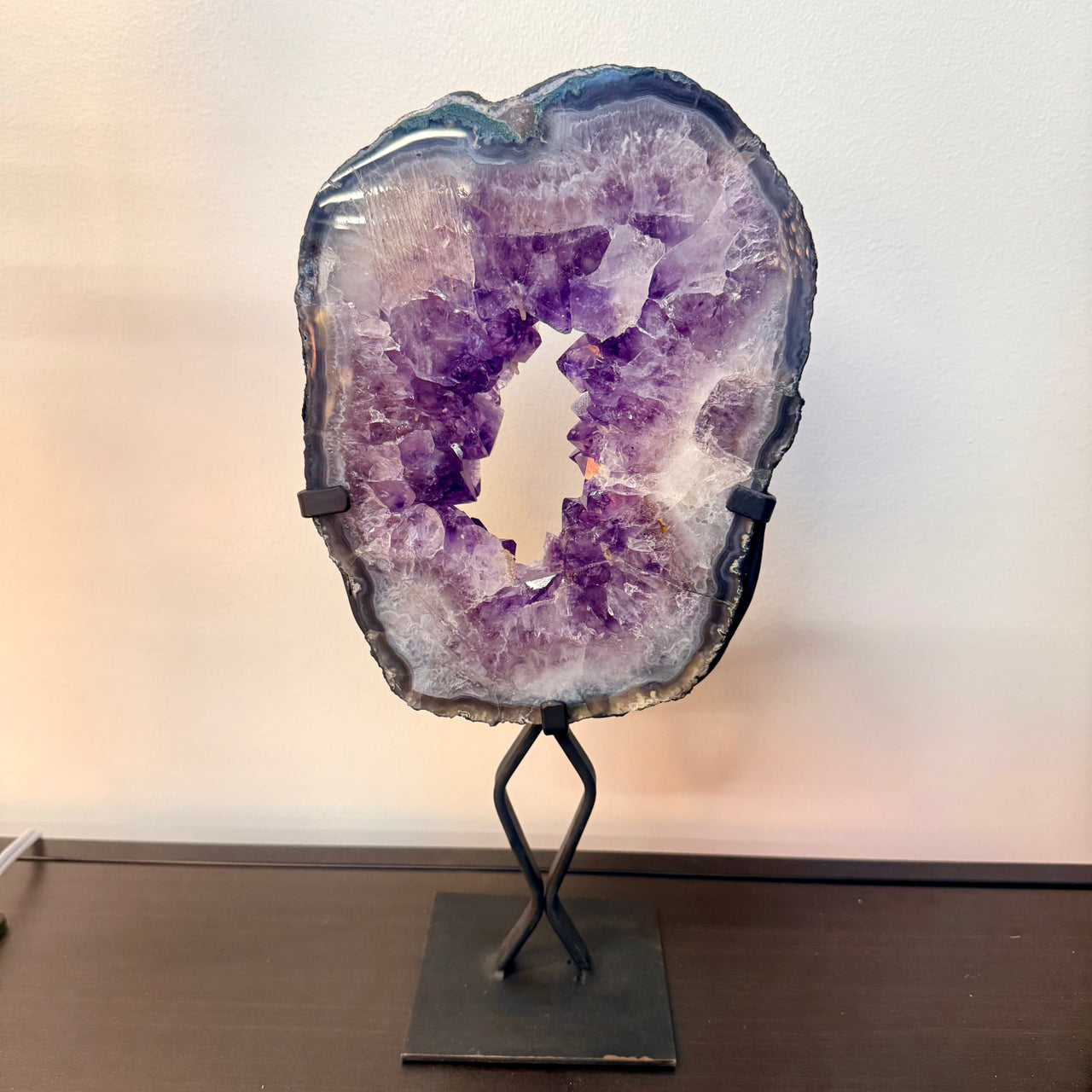 A stunning purple amethyst geode 9 inch portal ring specimen with intricate crystals and polished natural edge on stand