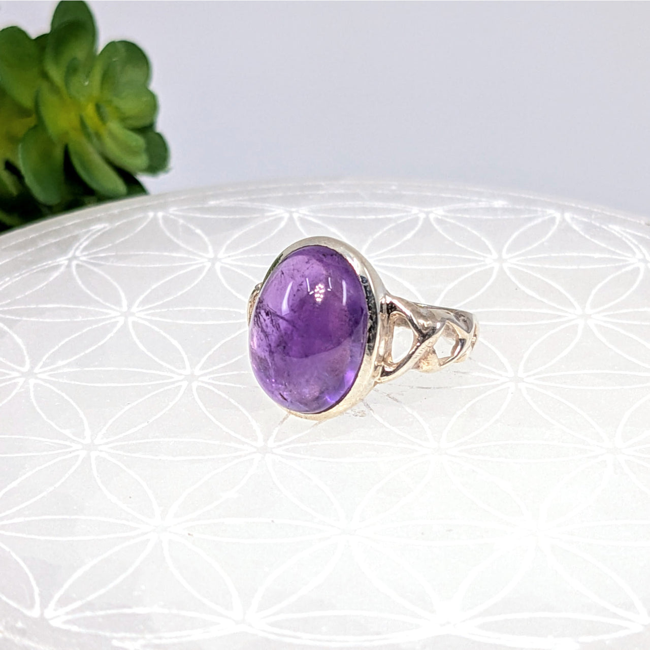 Silver ring with oval purple amethyst and Celtic-style band detailing, size 6