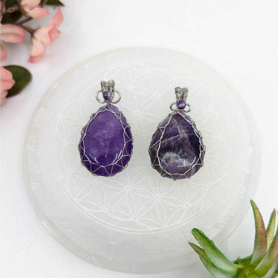Two amethyst teardrop wire wrap pendants showcasing protective light shield design