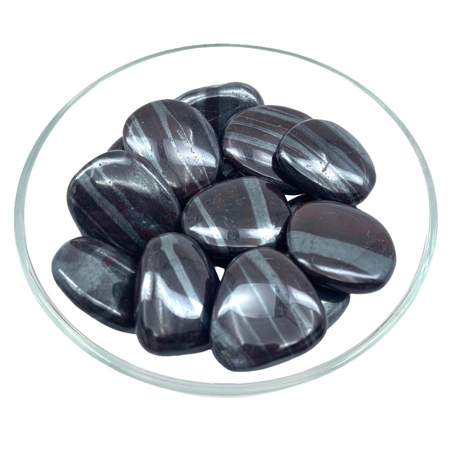 Polished black and gray striped Ancestralite Palm Stone approx 1.5 inches in a glass dish