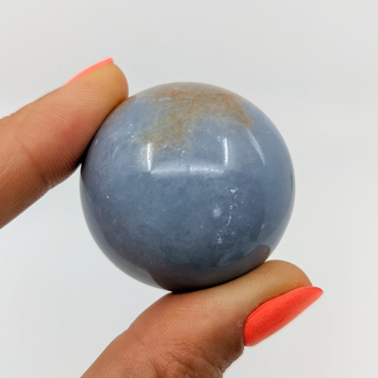 Hand holding Angelite Sphere w/ Ring Stand, blue marble ball, product #SK8711