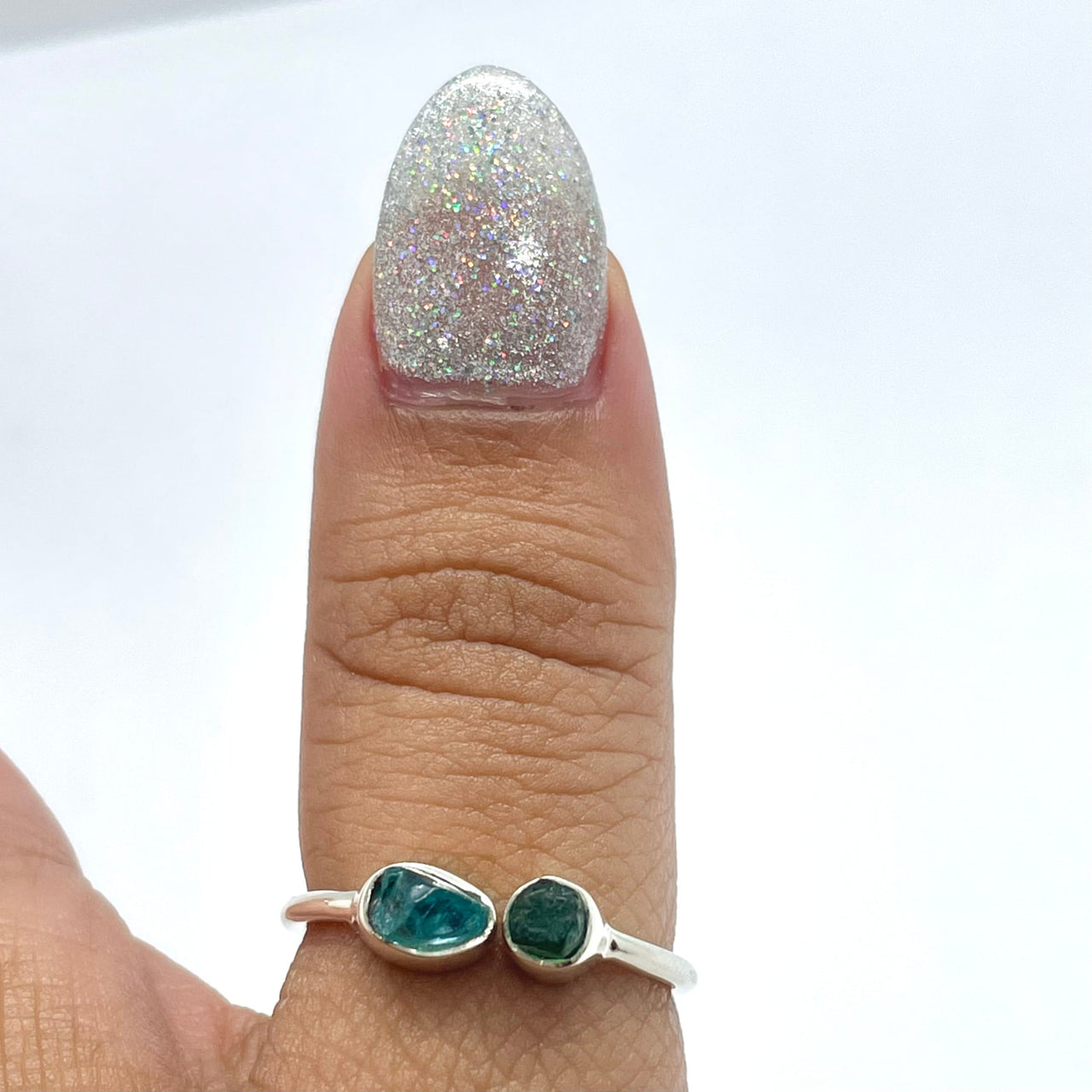 Close-up of a woman’s hand wearing Apatite & Emerald Natural Adjustable Dainty Silver Ring