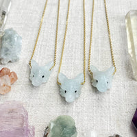 Three light blue jade fox necklaces with black bead eyes on gold chains