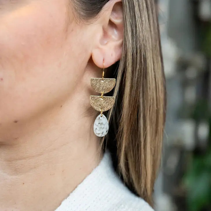 Woman wearing Aria Earrings Pebble LV3826, showcasing modern jewelry elegance