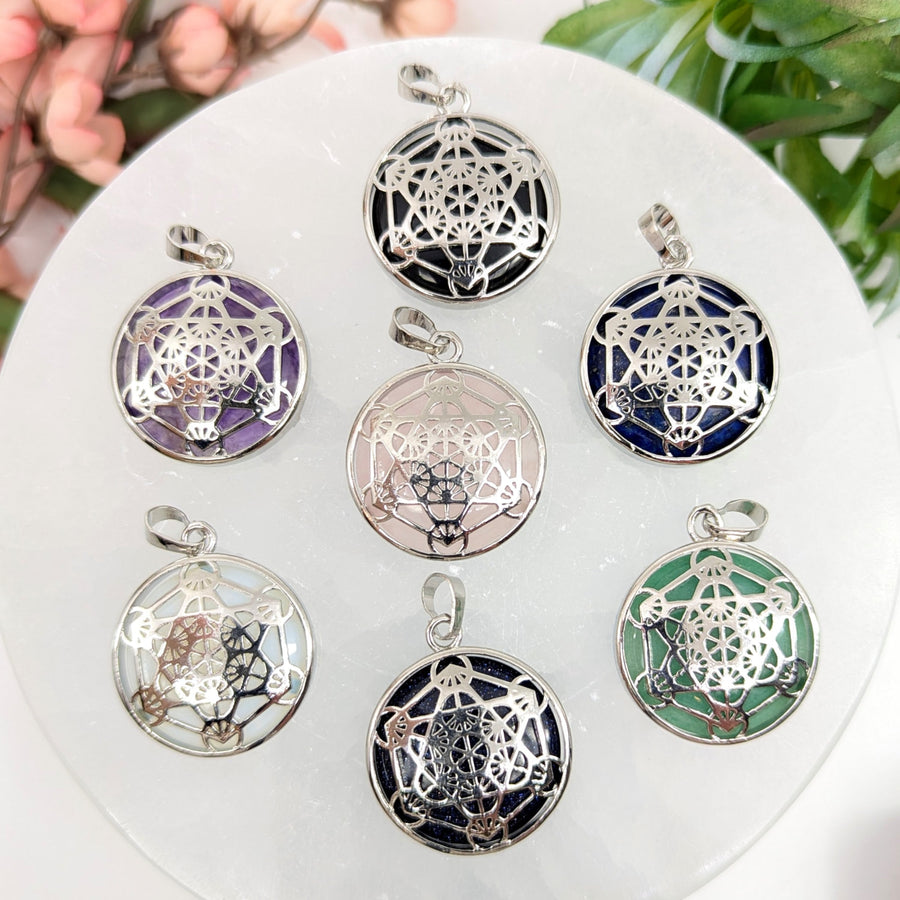 Seven colorful crystal pendants displayed in the Assorted Crystal 1 inch Metatron Pendant