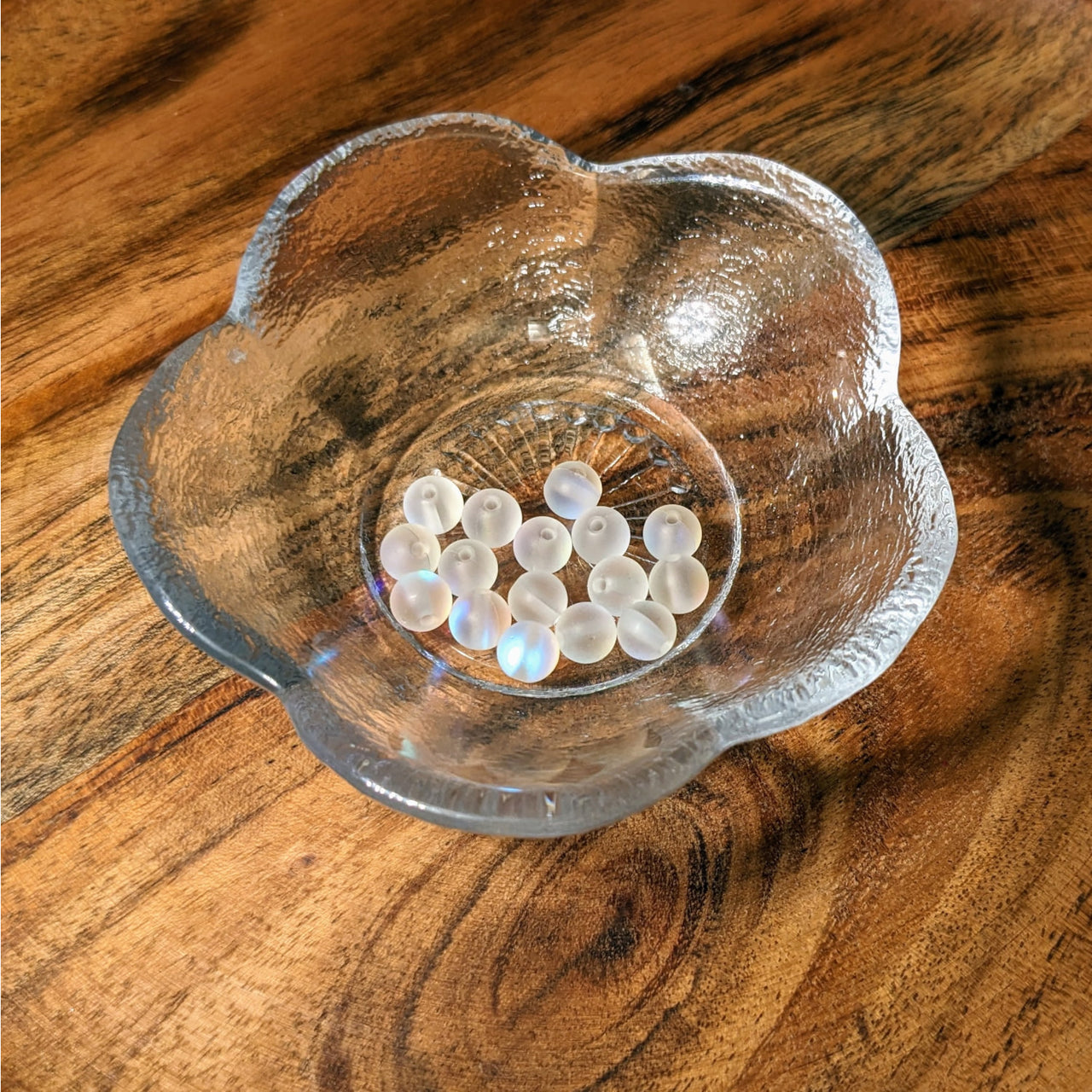 Glass bowl filled with small white pebbles for Aura Quartz 6 mm Round Bead 6 pack #LV3624