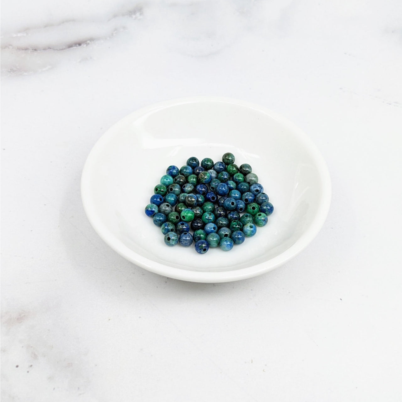 Azurite Malachite 4mm round beads in blue and green, displayed in a white bowl