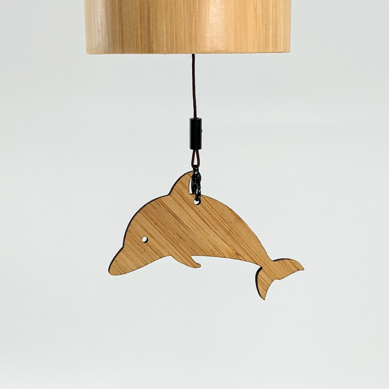 Wooden dolphin lamp hanging on a wall with Bamboo Concert Chime 14’ for the Seasons #LV1882