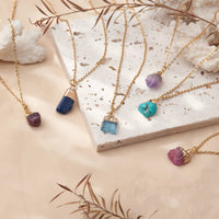 Birthstone necklaces with raw gemstone pendants on adjustable brass chains