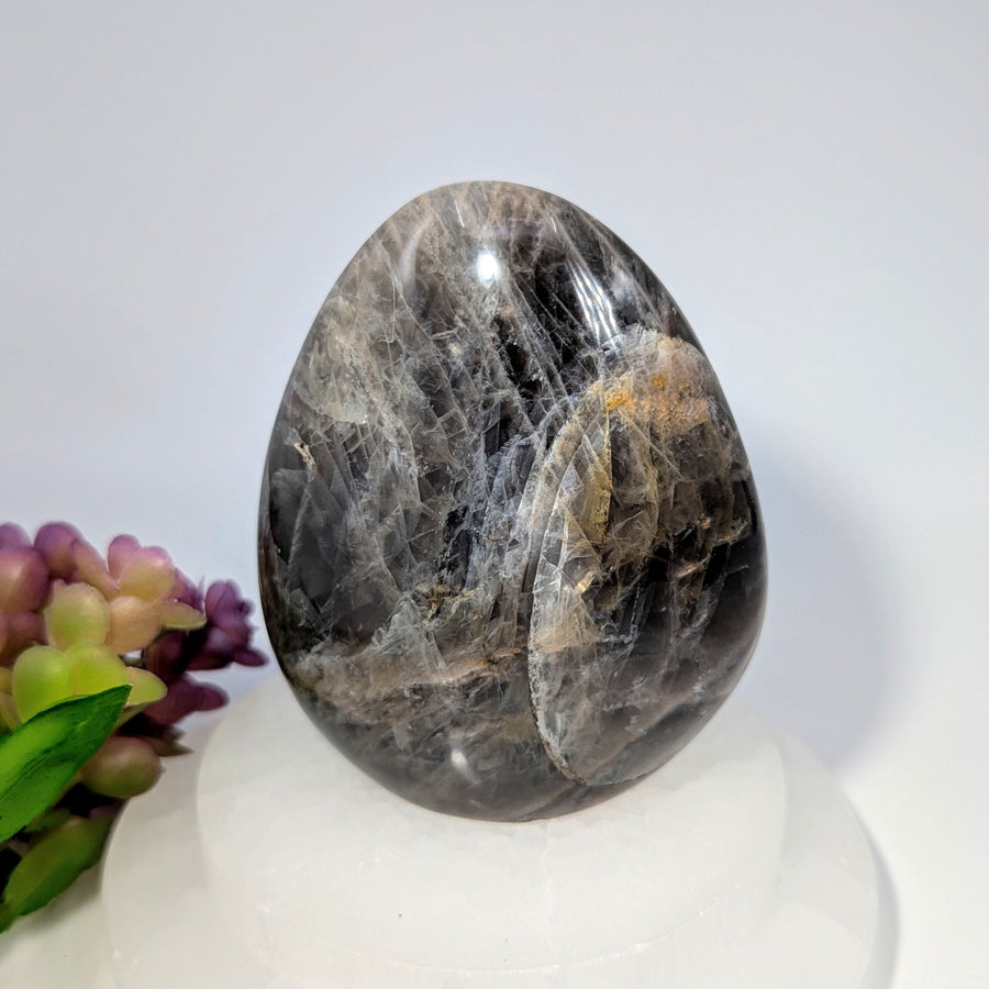 Polished Black Moonstone 4-inch freeform crystal egg with white veining on white base
