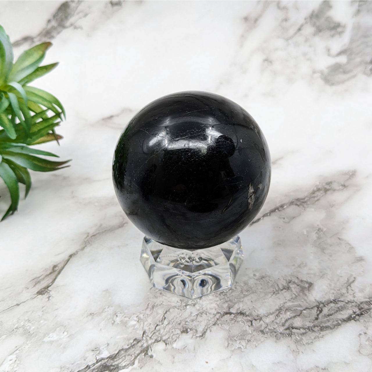 Black Tourmaline 2.4’ Sphere #LV5247 on a marble table for elegant decor and healing
