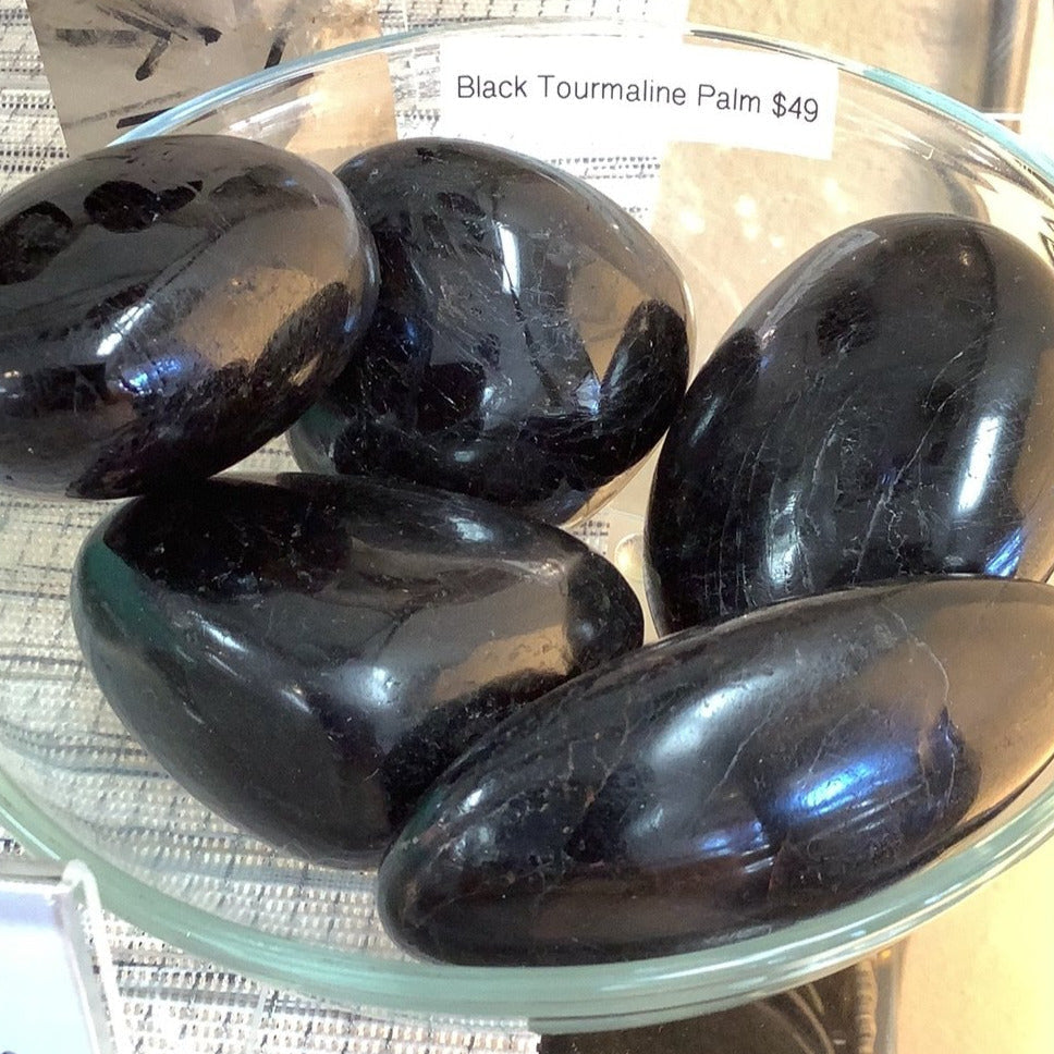 Polished black tourmaline palmstones displayed in a glass dish, Black Tourmaline Palmstone P018