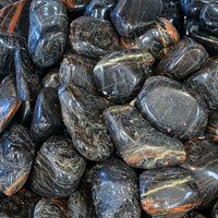 Thumbnail for Polished black tourmaline pebbles with orange and blue streaks for decor and healing