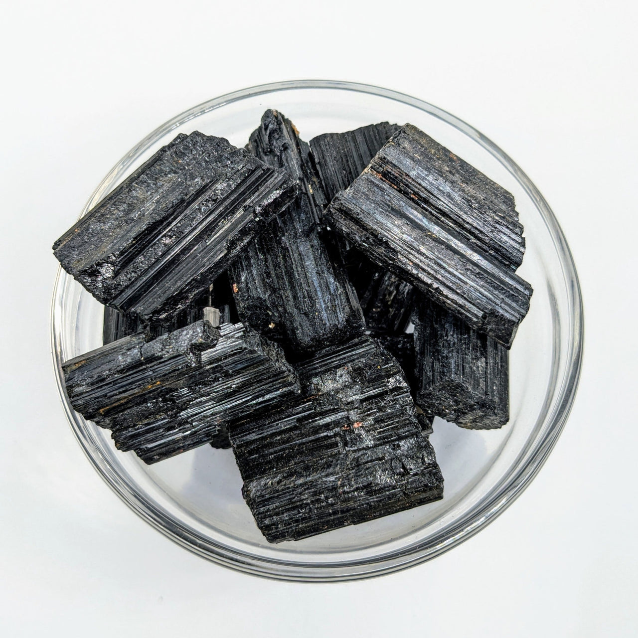 Black Tourmaline Rough chunks in glass dish showcasing item tier benefits and referral history