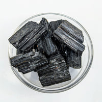 Thumbnail for Black Tourmaline Rough chunks in glass dish showcasing item tier benefits and referral history