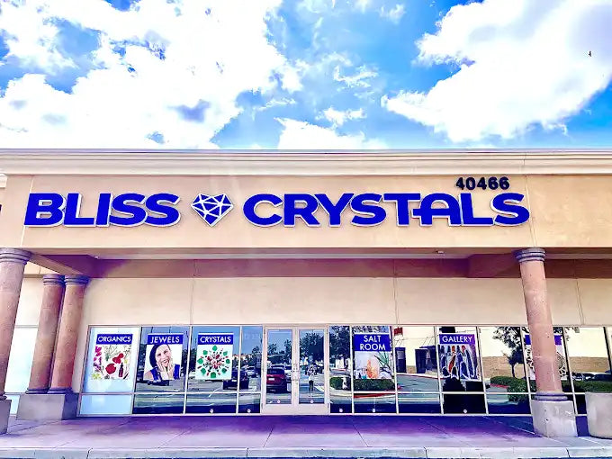 Bliss Crystals storefront with blue channel letter signage and window displays.