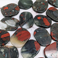 Thumbnail for Close-up of various colored rocks on a table showcasing Bloodstone 1.7’ Flat Palmstone #SK9731