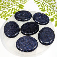 Blue goldstone 2-inch thumb stone #BC1238, six oval glossy speckled stones on glass plate