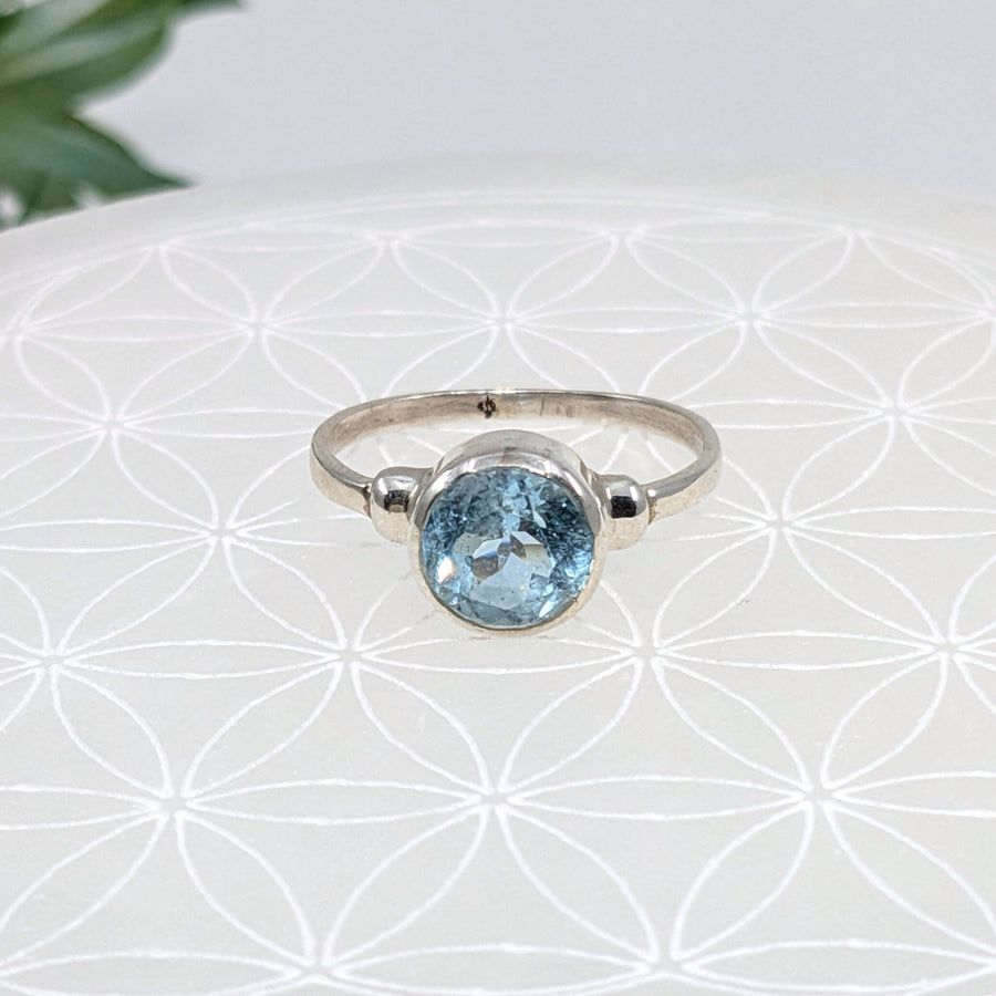 Silver round faceted ring with a stunning blue topaz gemstone in a stylish design