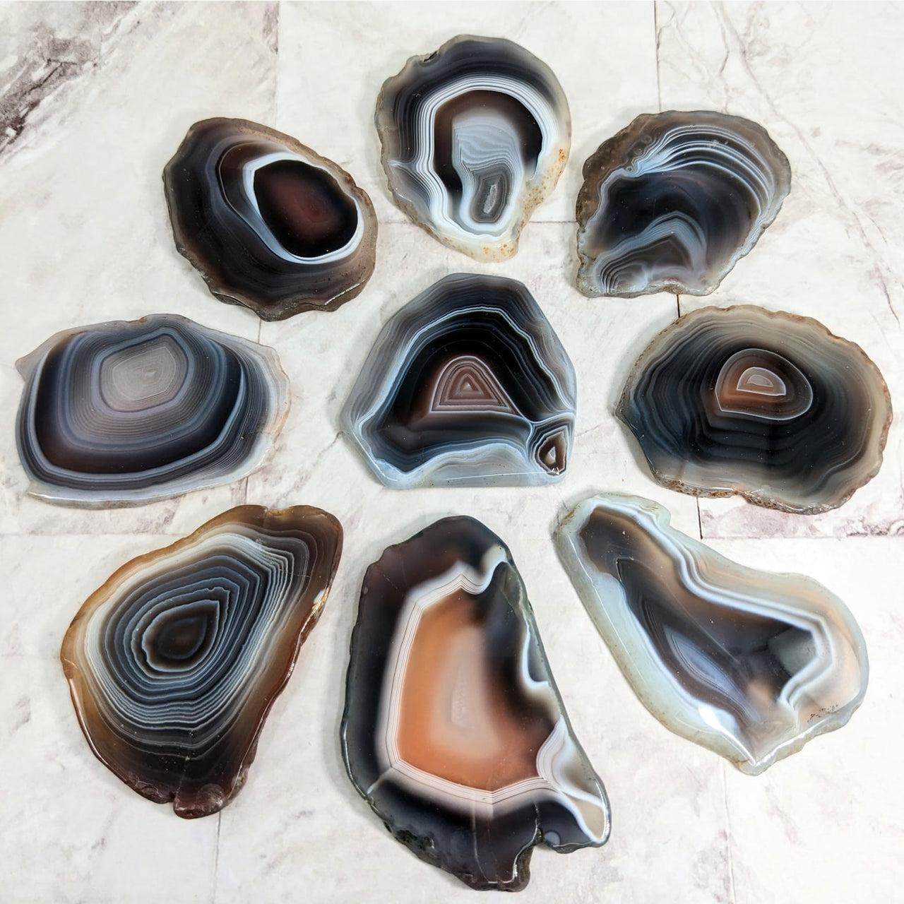 Arafed Botswana agate polished slice in flat shape on marble surface - product #LV2262