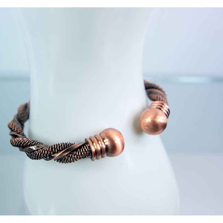 Copper-toned twisted wire bracelet with spherical end caps and magnets