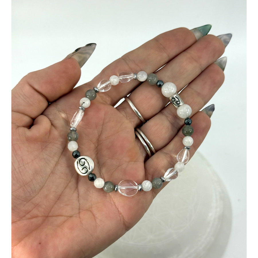 A delicate silver-toned cancer zodiac beaded bracelet with white gray beads and clear crystal accents 7 inches