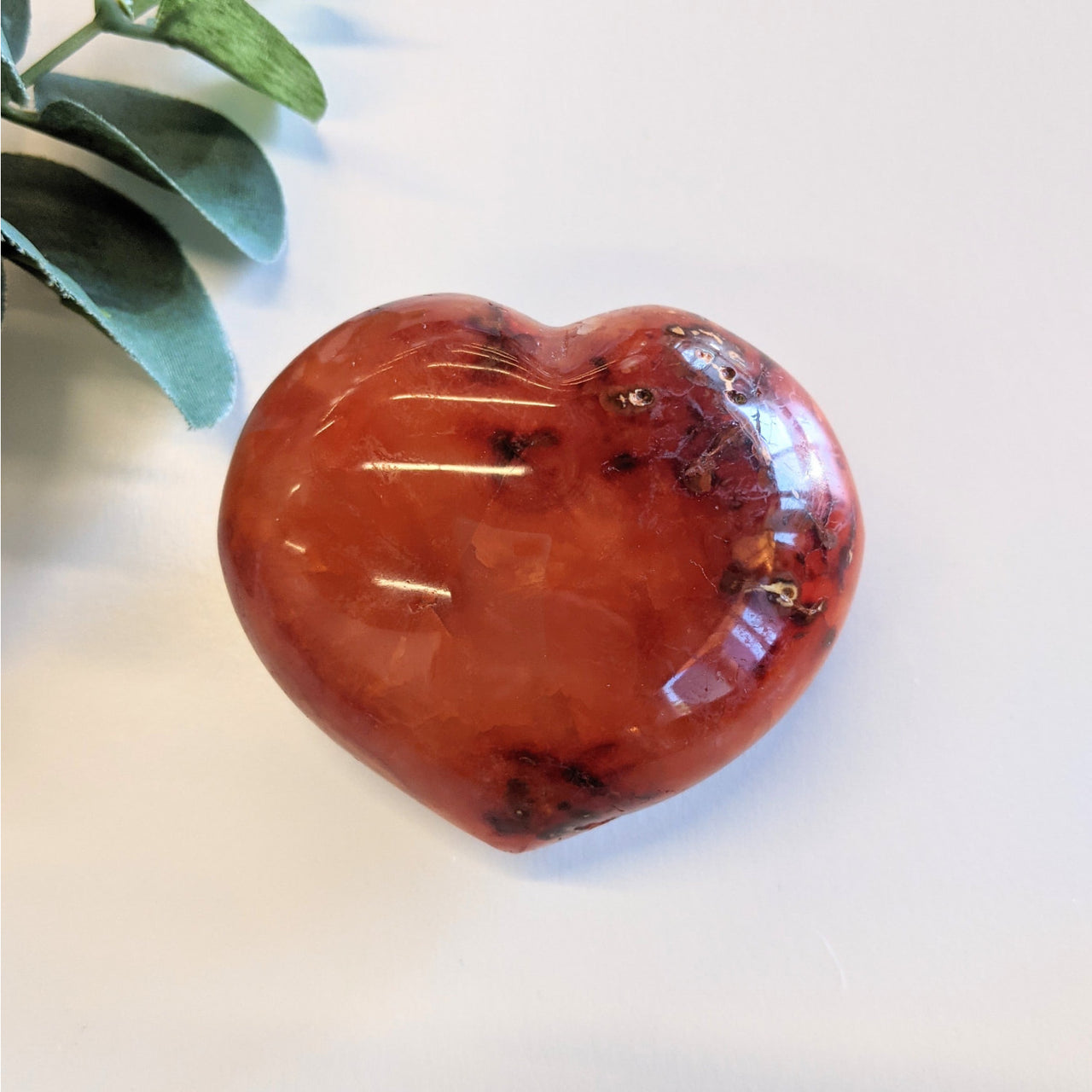 Heart-shaped polished red Carnelian crystal on stand offering item tier benefits