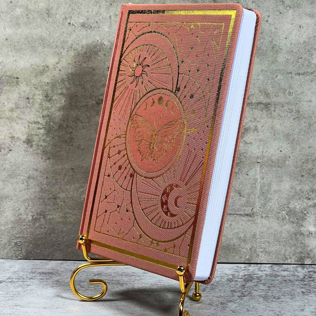 Rose gold Celestial Nature journal with moon phases on brass stand