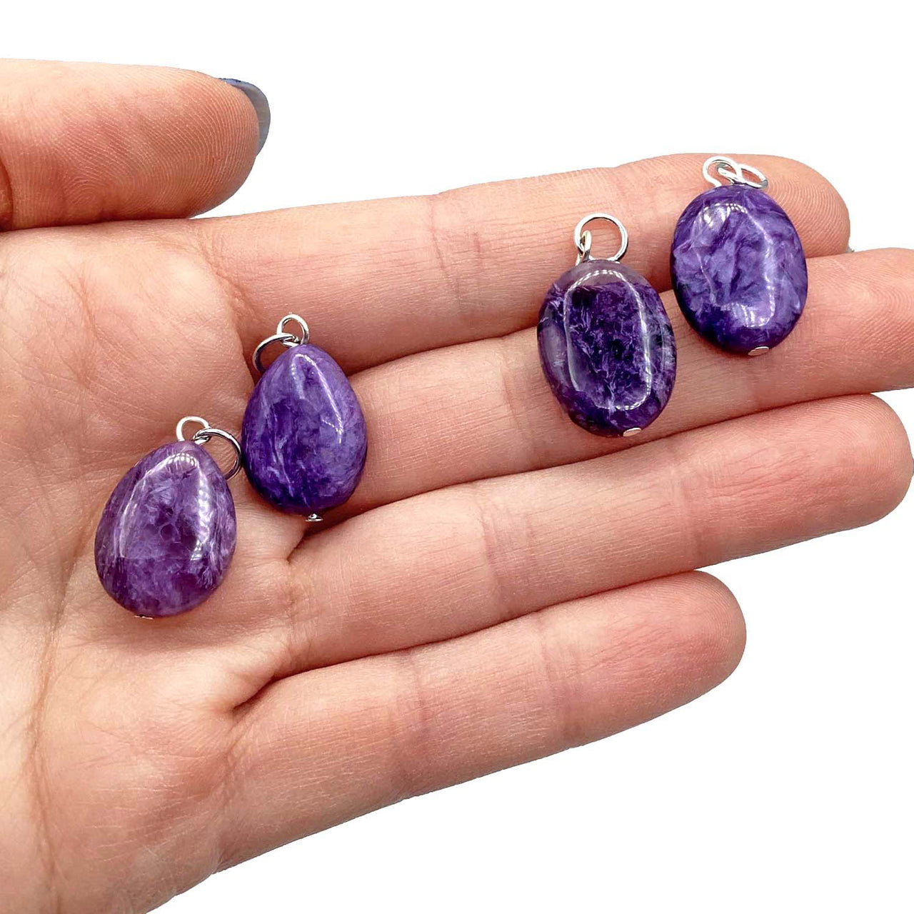 Four purple Amethyst crystal pendants with silver bails showcasing item tier benefits