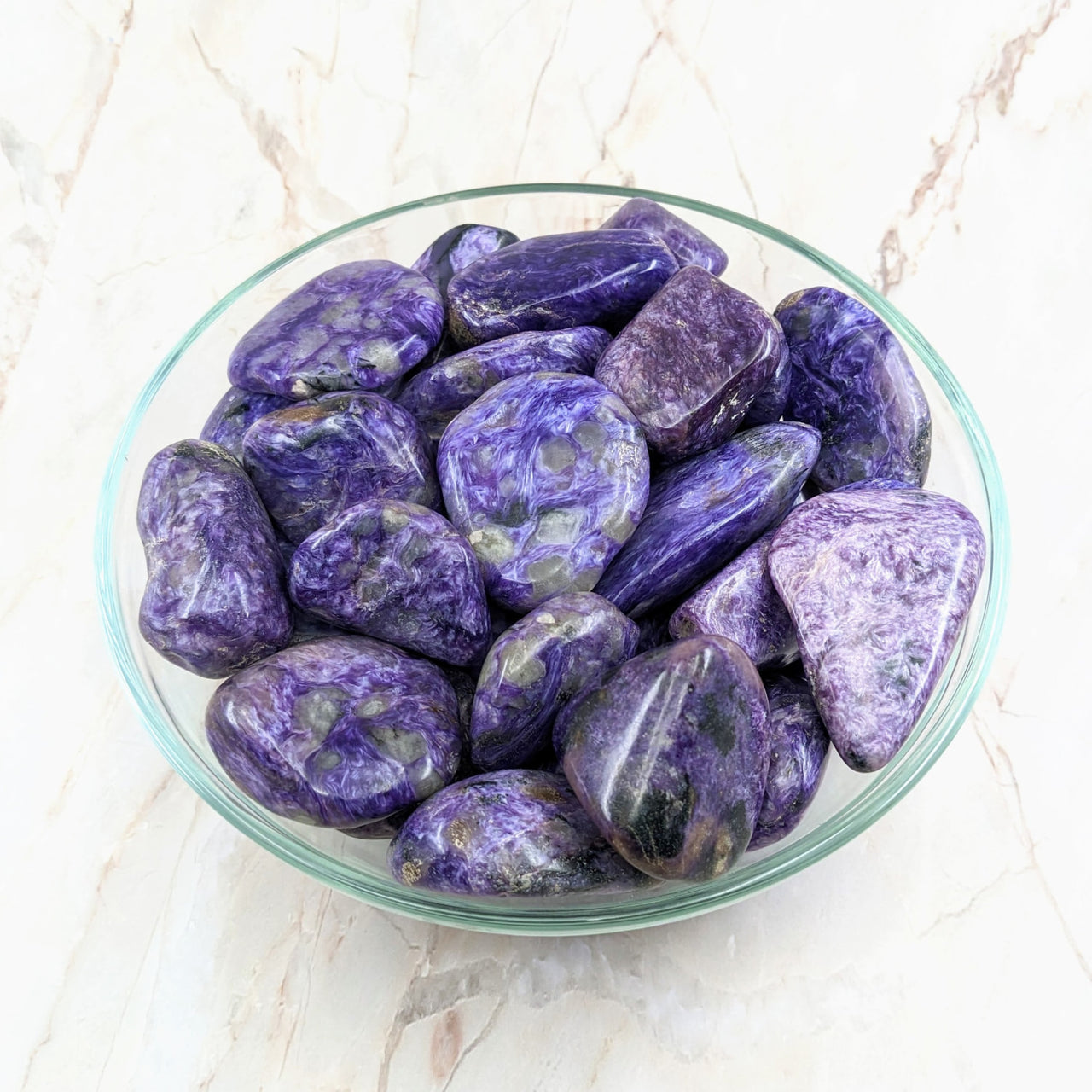 A bowl of purple and white marble containing Charoite Tumbled Stone #SK2183