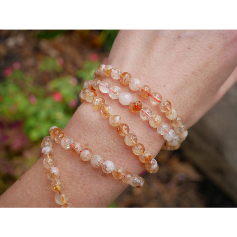 Three layered citrine 8 inch 6mm beaded bracelets made of translucent orange and white citrine beads